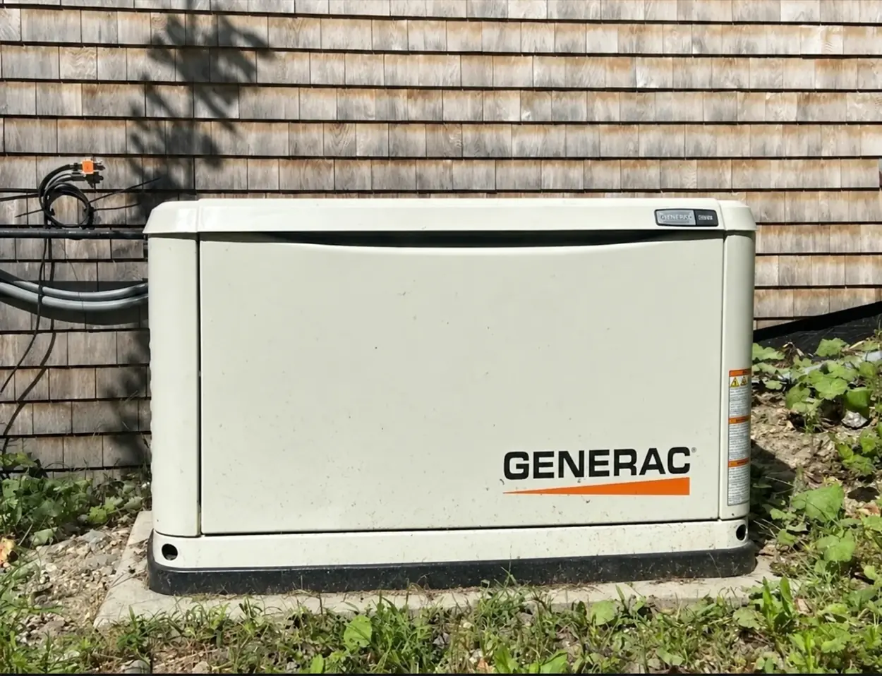 A Generac standby generator beside a home
